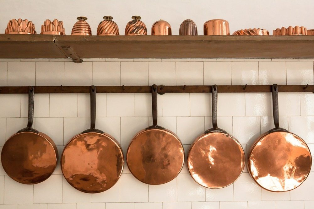 Copper pots and pans hanging on a wall