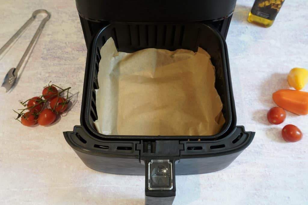 Air fryer with parchment paper lining the basket