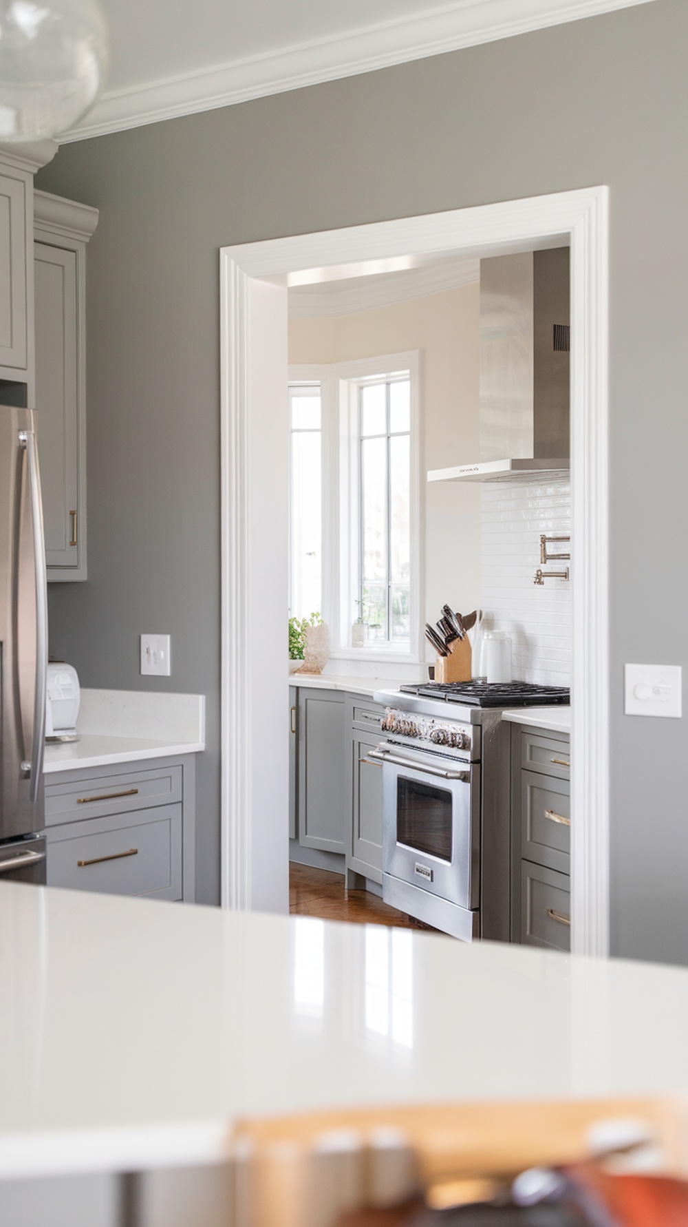 A kitchen featuring Anew Gray walls and cabinetry with stainless steel appliances.