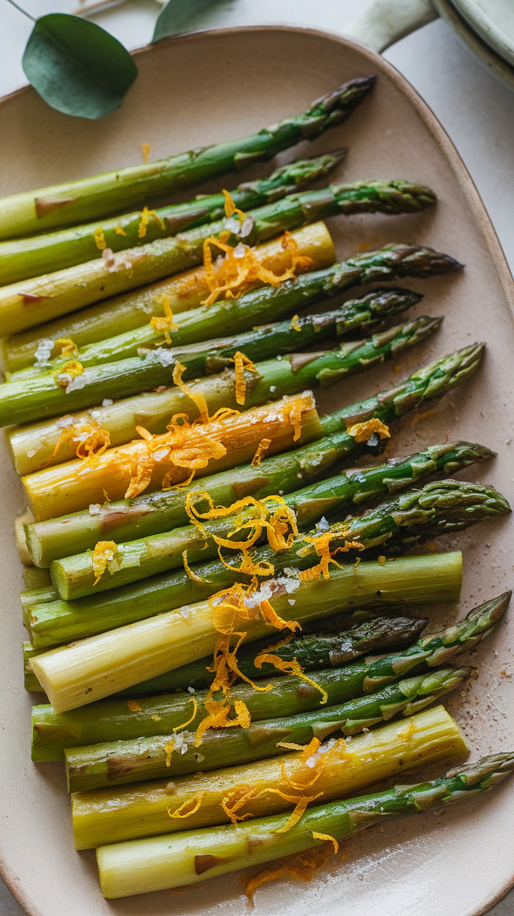 Grilled asparagus topped with lemon zest on a plate